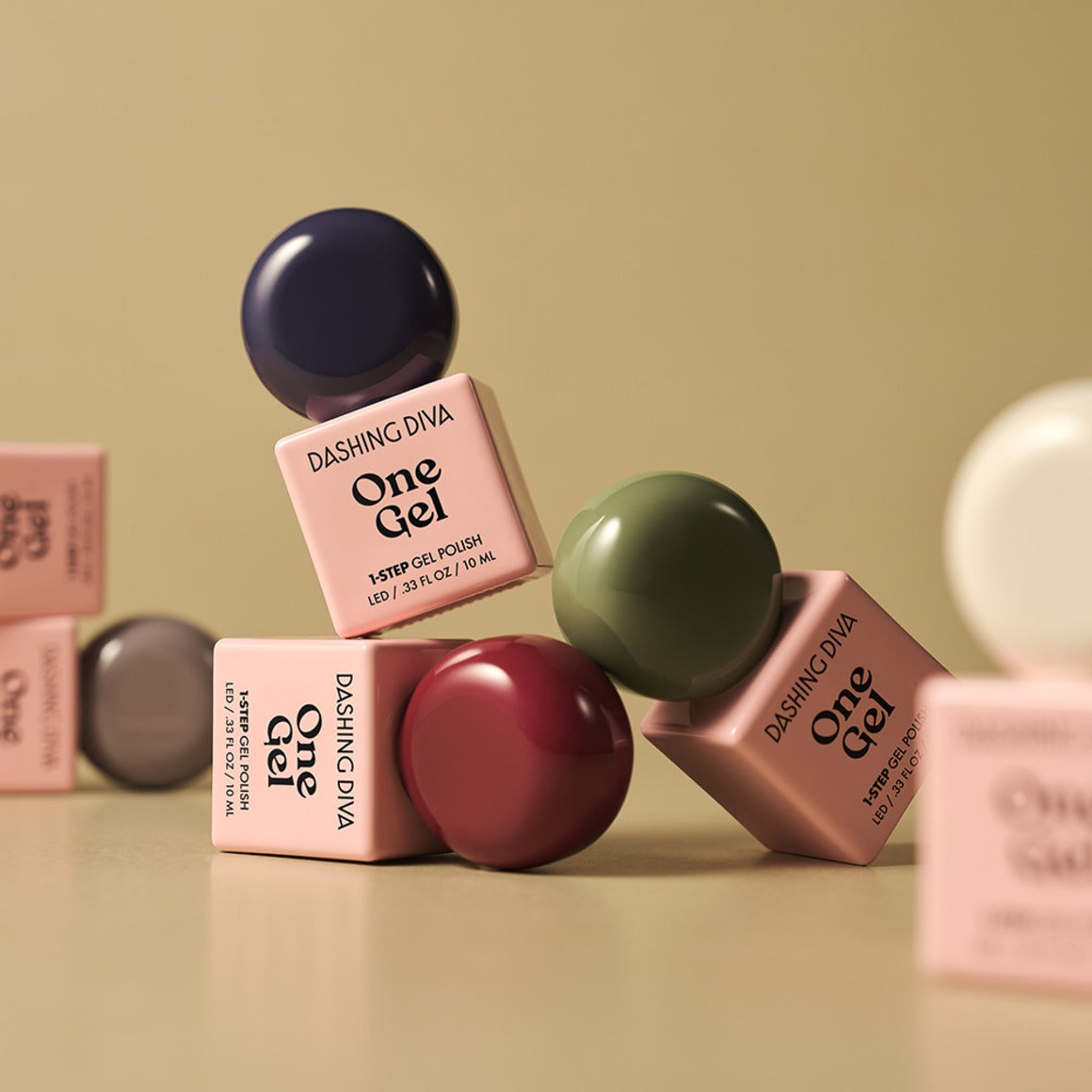 DASHING DIVA  Wonzel Autumn Depths : flacons One Gel aux tons automnaux, sur fond beige avec autres teintes de la marque.