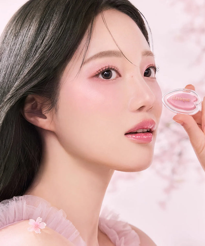 Femme tenant un fard à paupières DASIQUE Blooming Single Shadow, maquillage élégant et naturel.