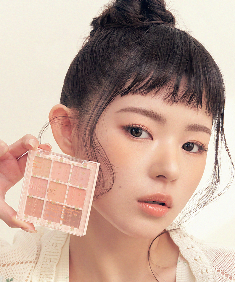 DASIQUE Shadow Palette 8g (#01 - #39) : palette maquillage DASIQUE tenue devant un visage maquillé, lumière douce