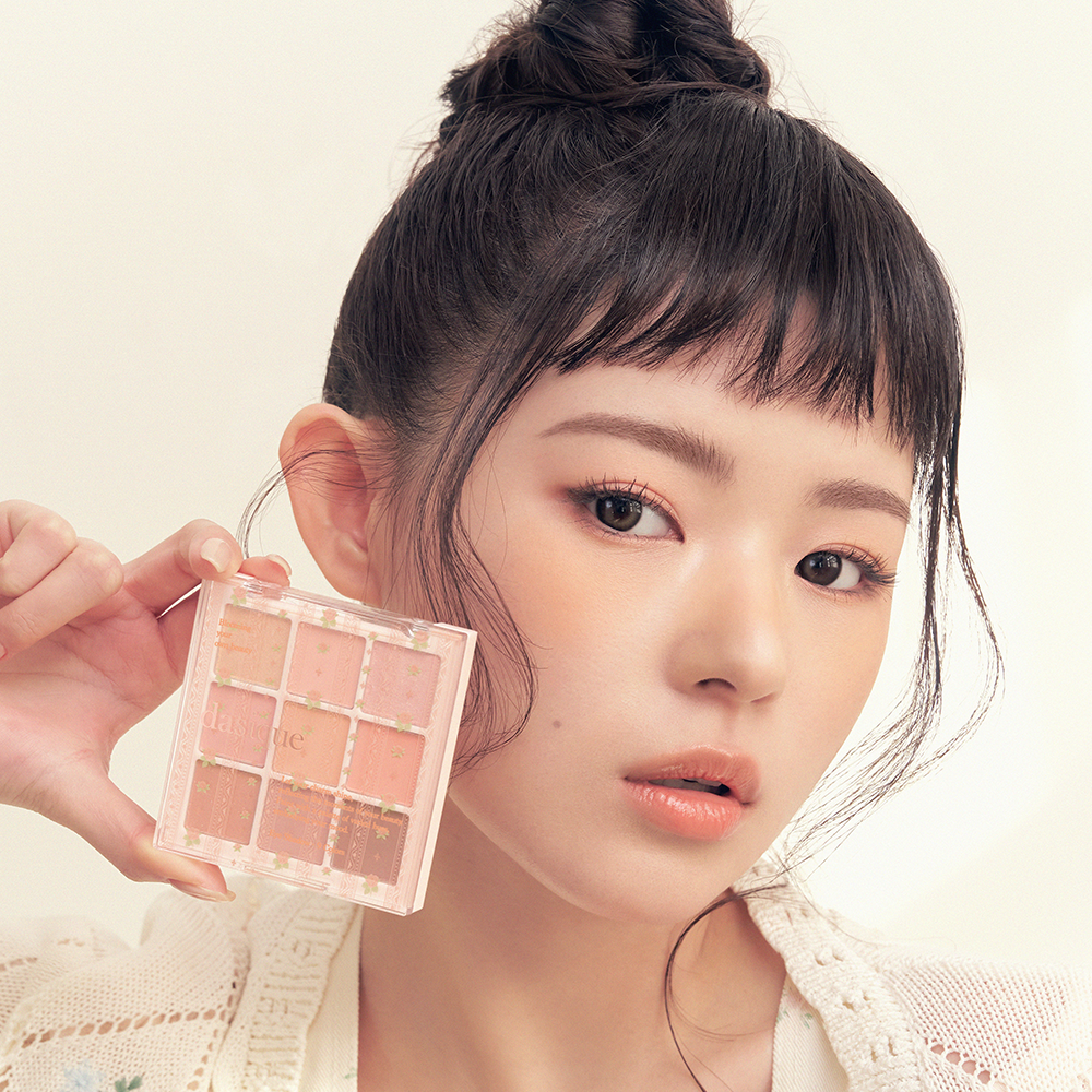 DASIQUE Shadow Palette 8g (#01 - #39) : palette maquillage DASIQUE tenue devant un visage maquillé, lumière douce