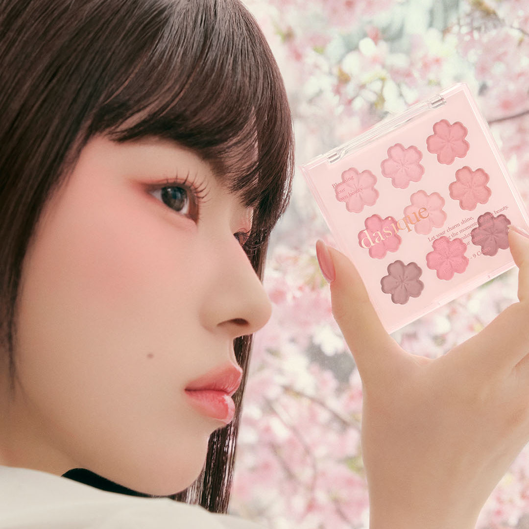 DASIQUE Shadow Palette 8g (#01 - #39), palette maquillage rose tenue près du visage, fleurs en arrière-plan