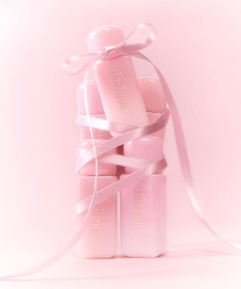 DASIQUE Silky Veil Blush de la marque DASIQUE, flacon rose en contexte maquillage, rubans satinés, fond pastel