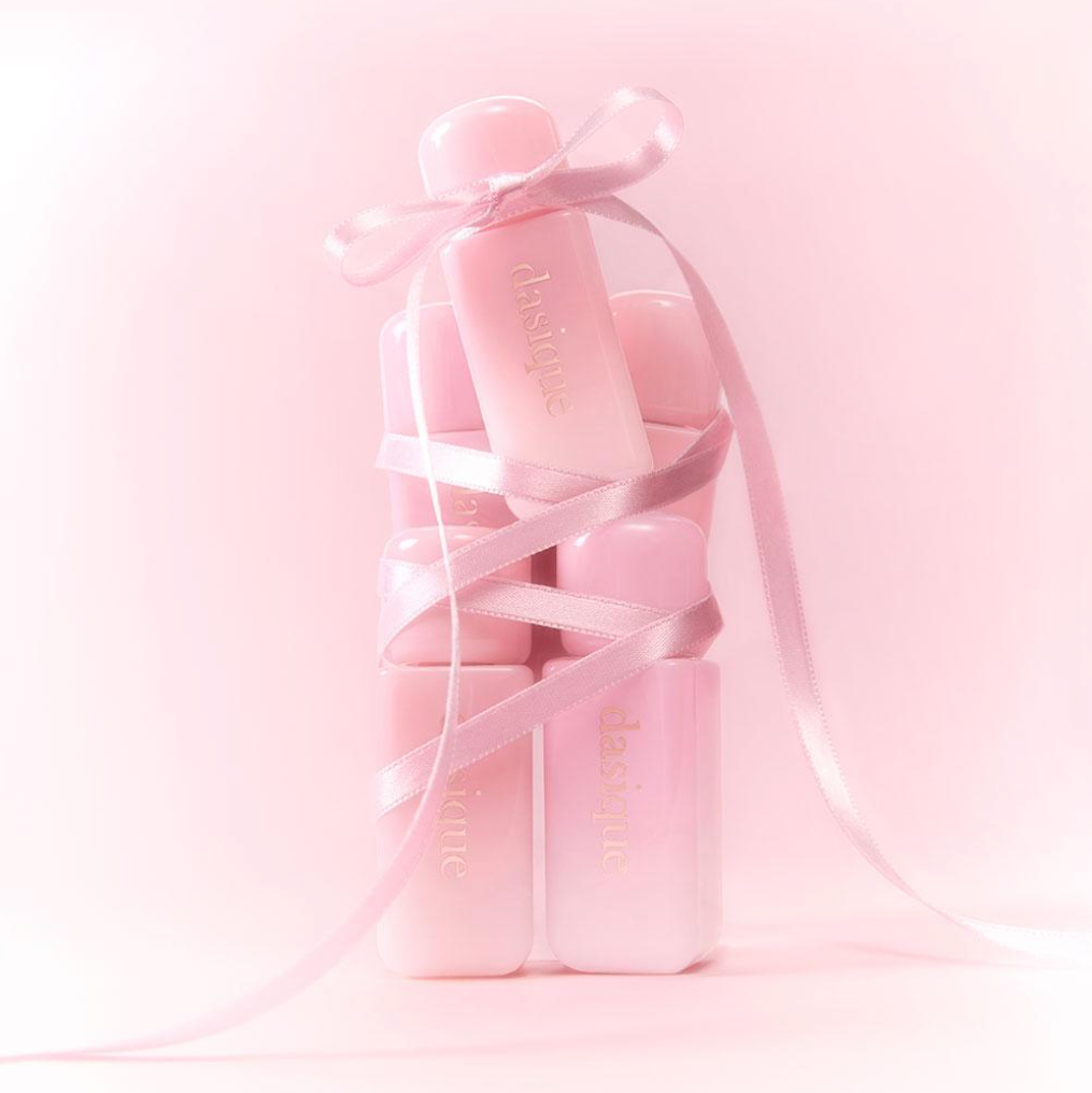 DASIQUE Silky Veil Blush de la marque DASIQUE, flacon rose en contexte maquillage, rubans satinés, fond pastel