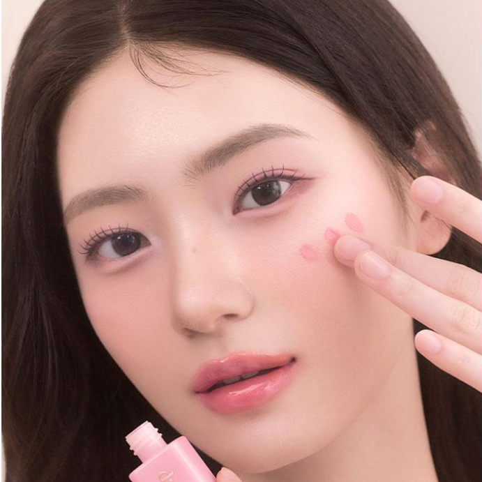 DASIQUE Silky Veil Blush sur peau maquillée, main appliquant le blush rose; marque DASIQUE, portrait beauté.