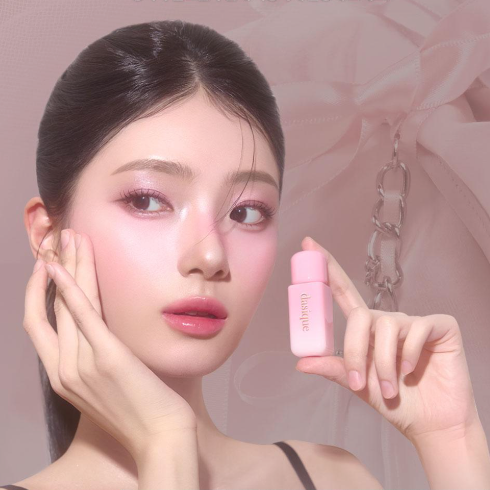 Maquillage: DASIQUE Silky Veil Blush, marque DASIQUE, sur modèle près d’un flacon rose, fond rose.
