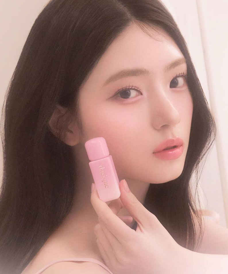 Portrait maquillage : DASIQUE Silky Veil Blush de la marque DASIQUE, blush rosé sur peau, main tenant le produit