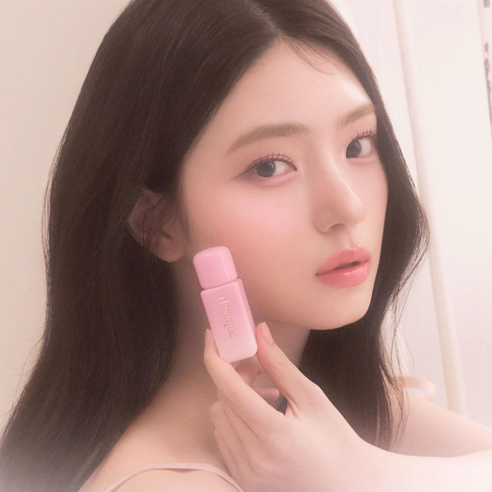 Portrait maquillage : DASIQUE Silky Veil Blush de la marque DASIQUE, blush rosé sur peau, main tenant le produit