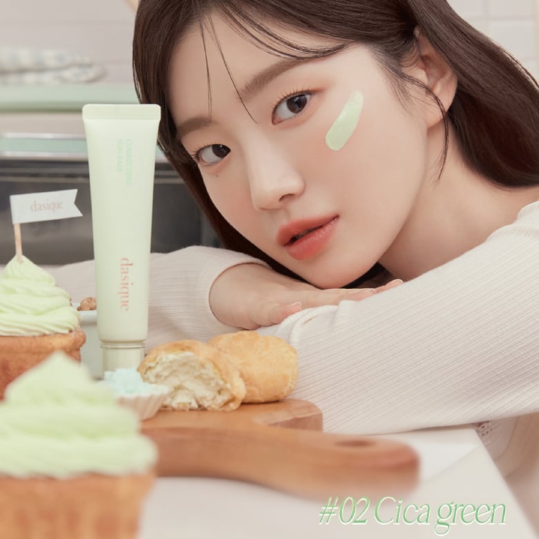 Portrait en lumière douce : DASIQUE Correcting Sun Base 30ml de la marque DASIQUE, tube vert sur table près d’un croissant