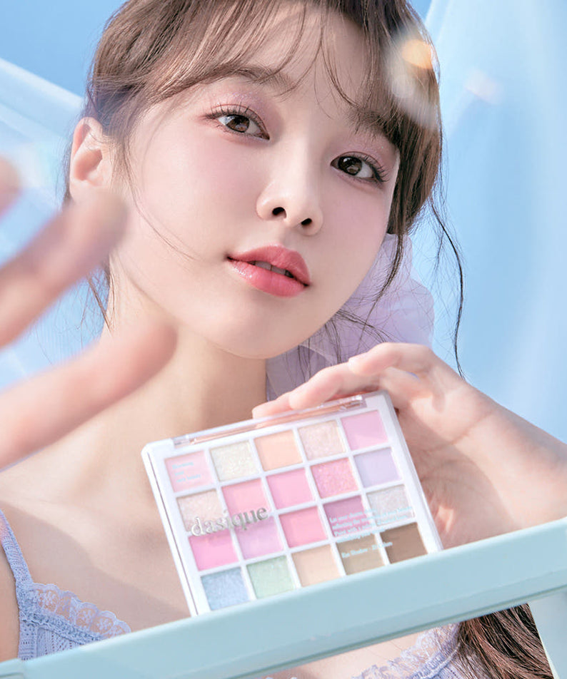 Portrait maquillage : DASIQUE Mood Shadow Palette (#01 to #07) sur un miroir, palette yeux avec couleurs pastel, fond bleu.