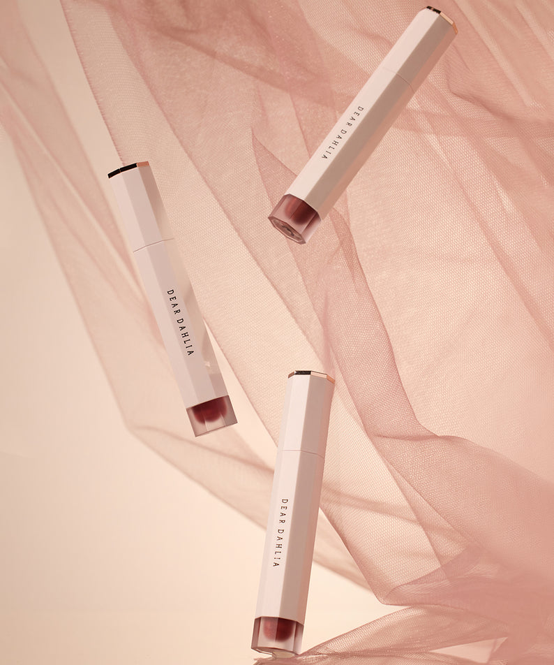 Stylish packaging of DEAR DAHLIA Dream velvet Lip Cloud sur un fond rose élégant et doux en tissu, beauté et sophistication réunies.