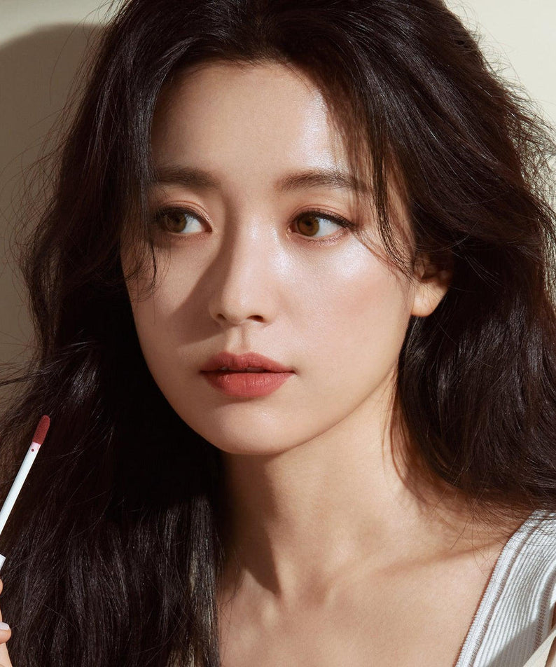 Femme appliquant le DEAR DAHLIA Dream velvet Lip Cloud, maquillage glamour et élégant, beauté naturelle.