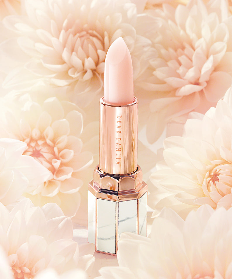 Raffinement et élégance avec DEAR DAHLIA Paradise Blooming Night, rouge à lèvres rose posé sur fond de dahlias blancs luxuriants.