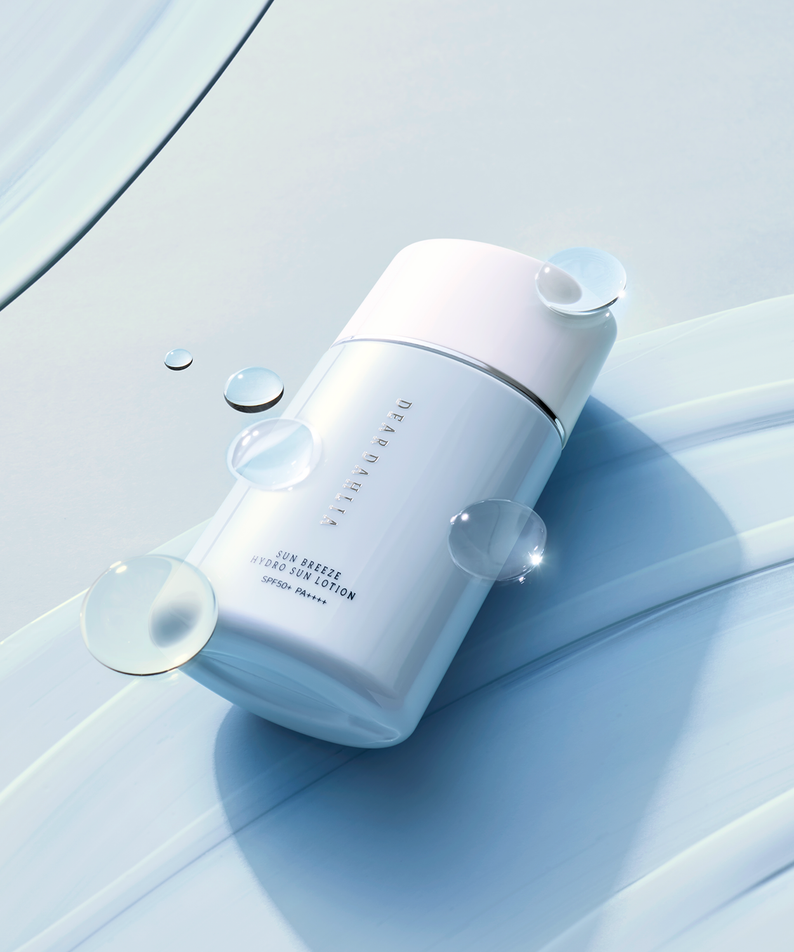 DEAR DAHLIA Sun Breeze Hydro Sun Lotion avec texture légère et hydratante sur fond bleu.