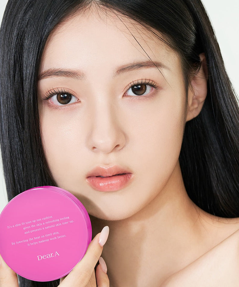 Femme tenant le DEAR.A Slim Fit Tone-Up Sun Cushion 30ml, mettant en valeur un produit cosmétique de soin solaire tonifiant.