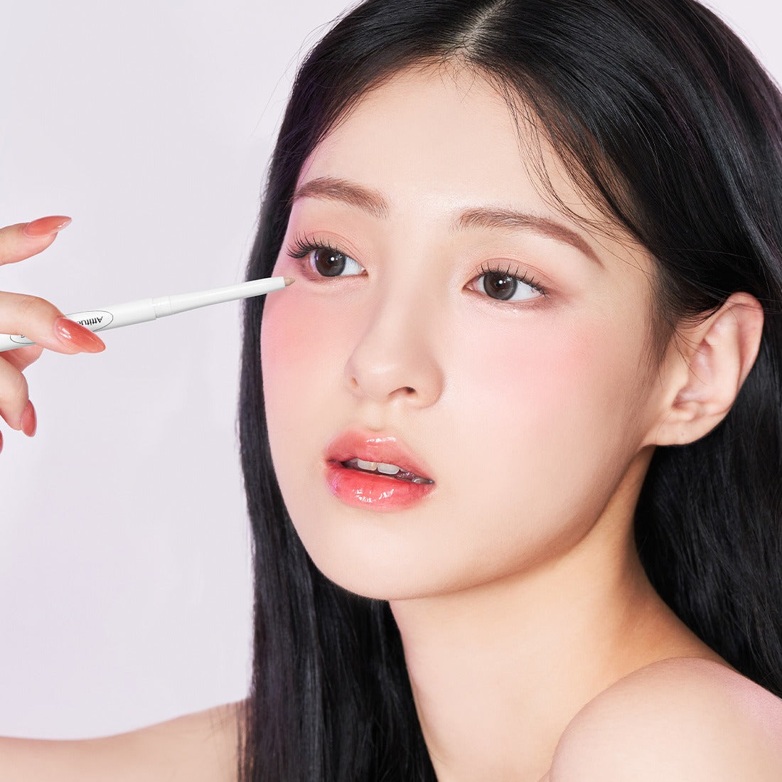DEAR.A Slim Tip Cute Eyes Maker : maquillage des yeux avec un embout fin, main appliquant près du regard sur fond clair.