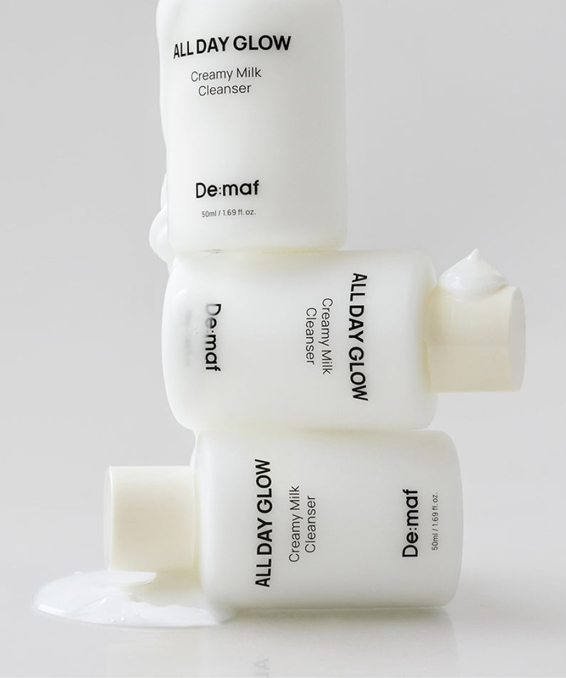 DE:MAF All Day Glow Creamy Milk Cleanser 50ml de De-Maf, flacons crème et lait nettoyant sur fond clair.