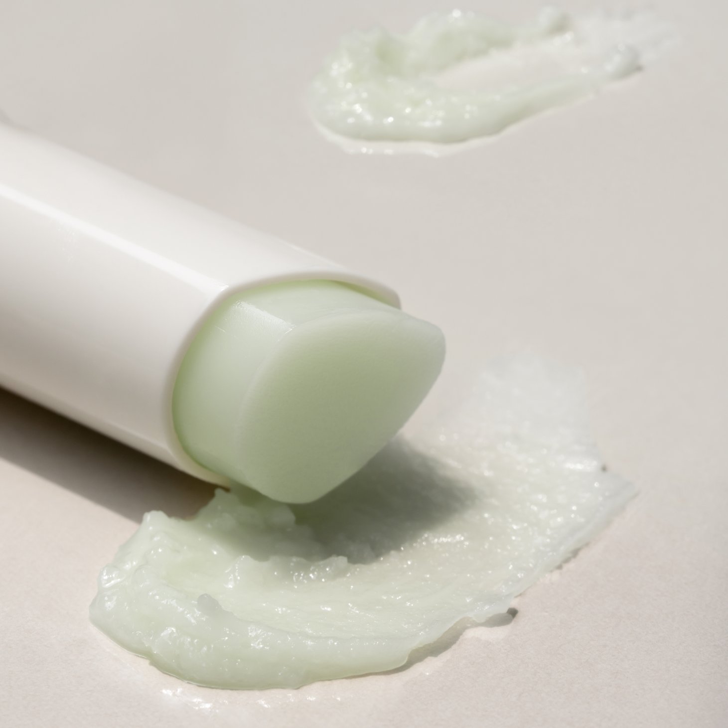 DE:MAF Eye Glow Jojoba Oil Multi Balm 9g de marque DE:MAF, baume crème vert appliqué près de l’œil, texture au gros plan.