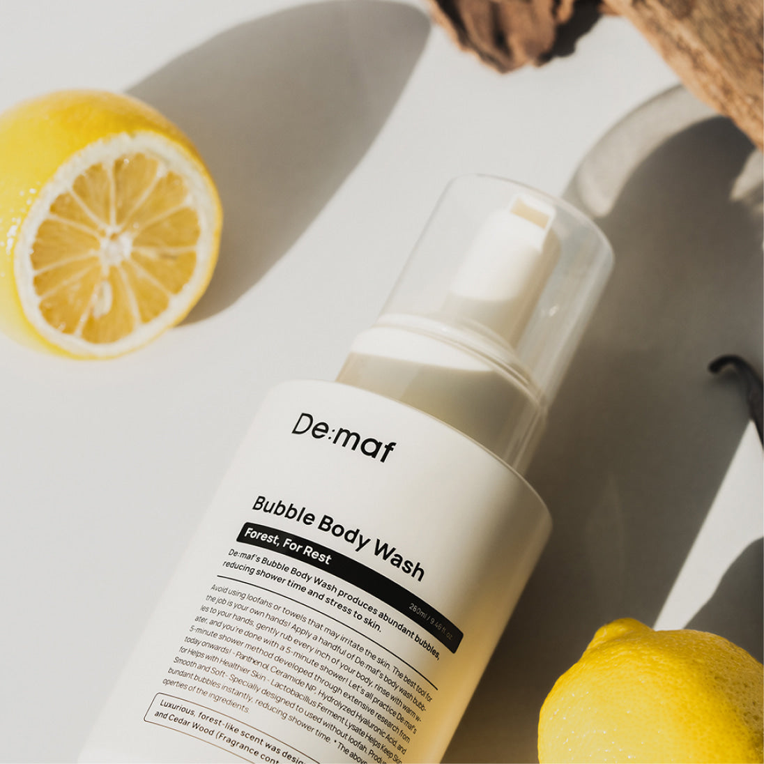 DE:MAF Forest Bubble Body Wash 280ml De:maf, flacon blanc sur serviette avec citrons, ambiance spa, salle de bain