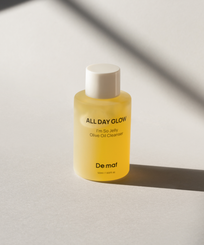 DE:MAF I'm So Jelly Olive Oil Cleanser 50ml, bouteille jaune Demaf, sur fond clair ensoleillé, style minimaliste