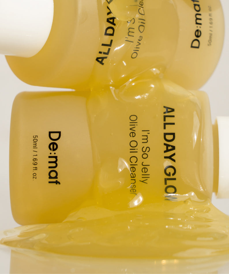 DE:MAF I'm So Jelly Olive Oil Cleanser 50ml de DE:MAF, flacon et gel d’huile d’olive, visuel texture jaune.
