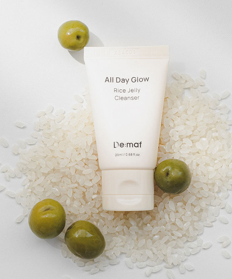 DE:MAF Rice Jelly Cleanser 20ml de De:maf, tube sur flocons de riz blancs, contexte visuel produit cosmétique