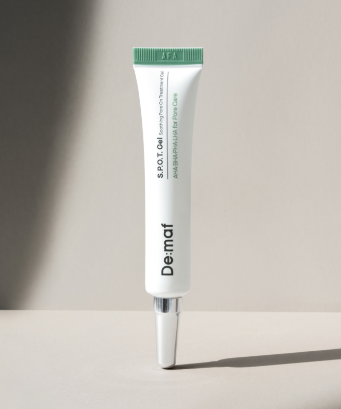 DE:MAF SPOT Gel Soothing Pore-On Treatment Gel 10g de DE:MAF, tube vert sur fond clair ensoleillé.