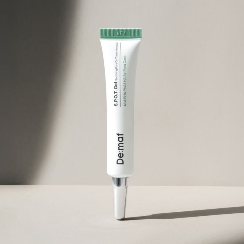 DE:MAF SPOT Gel Soothing Pore-On Treatment Gel 10g de DE:MAF, tube vert sur fond clair ensoleillé.