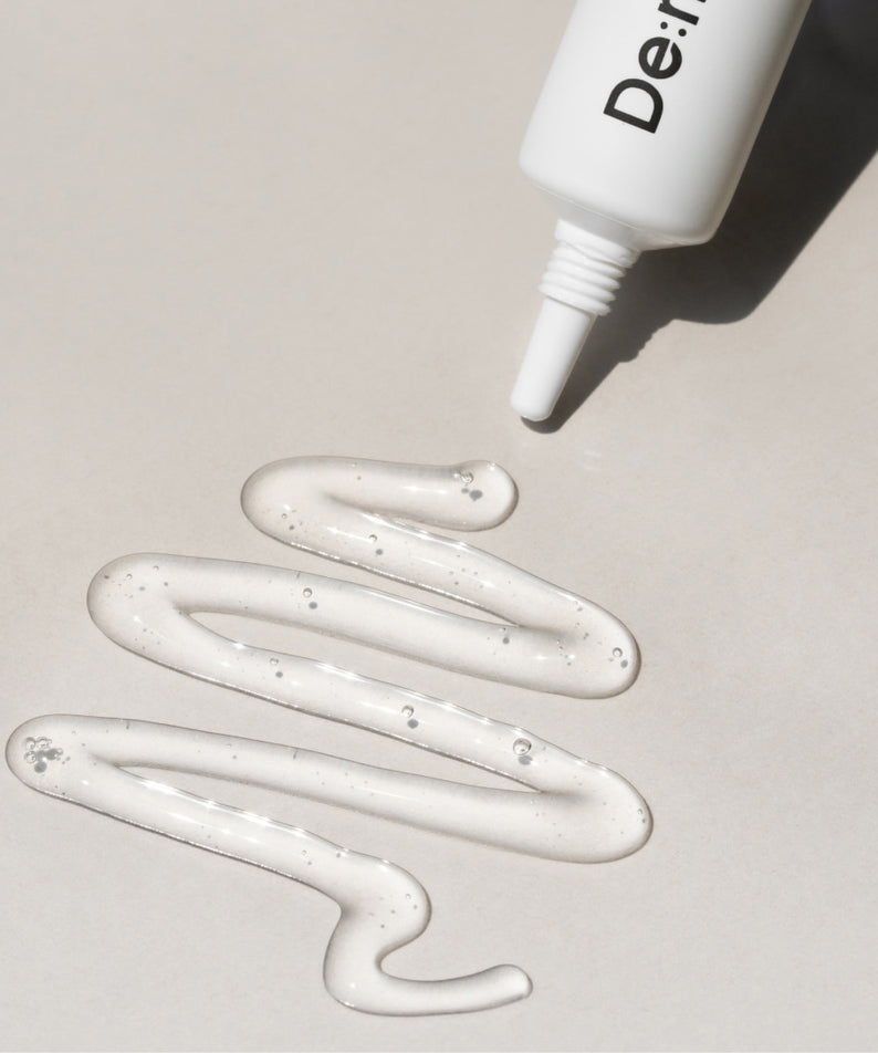 Décris l'image en français : DE:MAF SPOT Gel Soothing Pore-On Treatment Gel 10g, tube de marque, gel blanc sur fond clair.