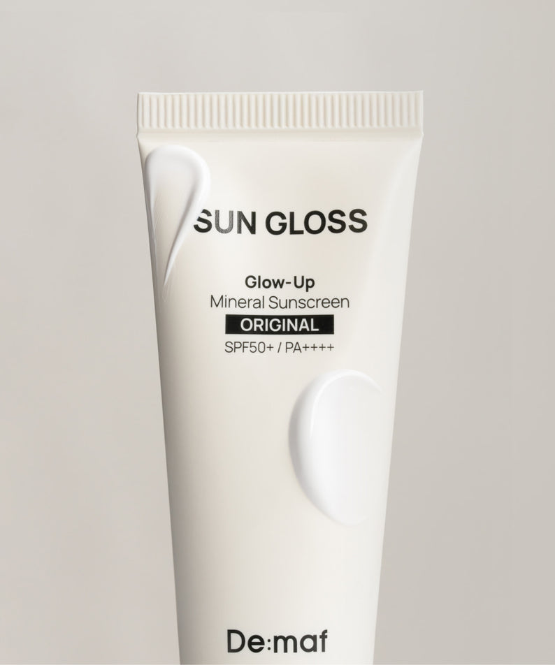 DE:MAF Sun Gloss Glow Up Inorganic Sunscreen 50ml Original, tube blanc sur fond clair, marque De:mof, écran solaire minéral SPF.