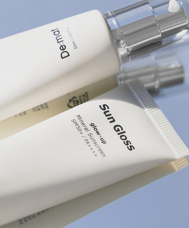 DE:MAF Sun Gloss Glow Up Non-Glowing Sunscreen 50ml de DE:MAF, tube cosmétique sur fond bleu, photo produit en gros plan