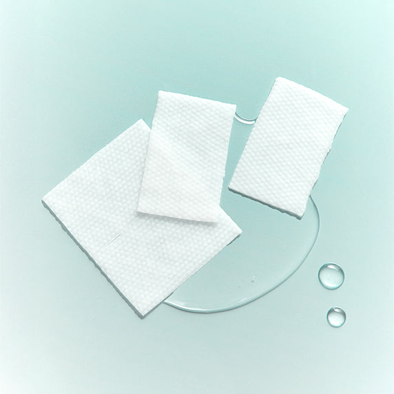 Décris l'image en français : DERMATORY Salicinic Pore Cleansing Water Pad 70 Sheets, coton-pads blancs sur fond bleu clair.