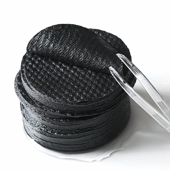 DERMATORY Salicinic Pore Clear Black Pad 70 Pads, marque DERMATORY, disques noirs pore, appliqués avec pince en gros plan.