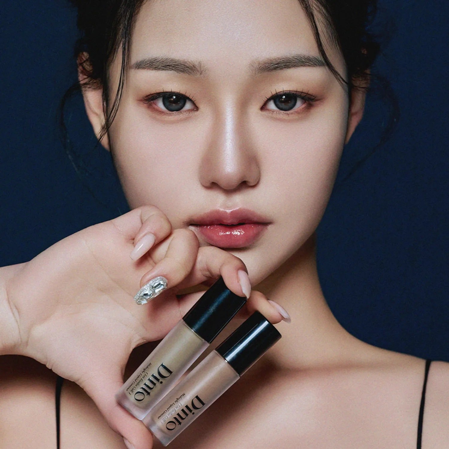 DINTO Midnight Liquid Contour 2 Types, flacons maquillage et contour, maquillage visage sur fond bleu nuit.