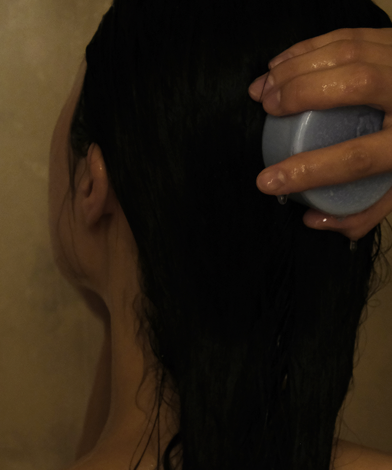 Femme utilisant le DONGGUBAT Field Correct Rinse Bar sur les cheveux mouillés, shampoing solide naturel pour soin capillaire