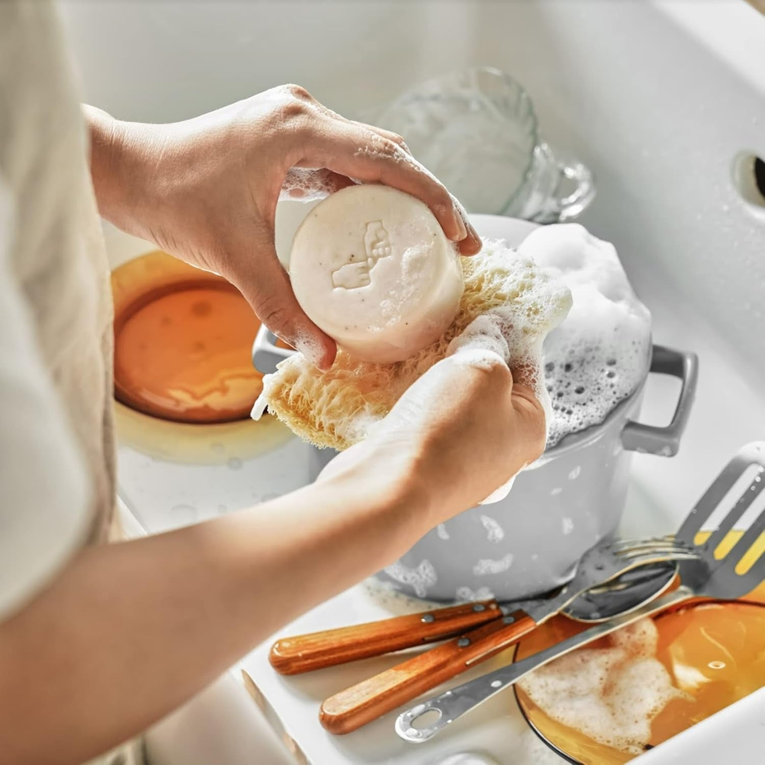 Décris l'image en français : DONGGUBAT Correct Dishwashing Washing Bar 500g de la marque DONGGUBAT, main tenant le savon.