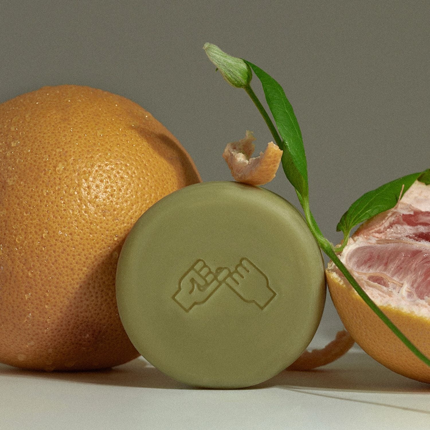 DONGGUBAT Correct Shampoo Bar For Dry Skin sur fond clair, entouré d’agrumes et de feuilles, marque DONGGUBAT.