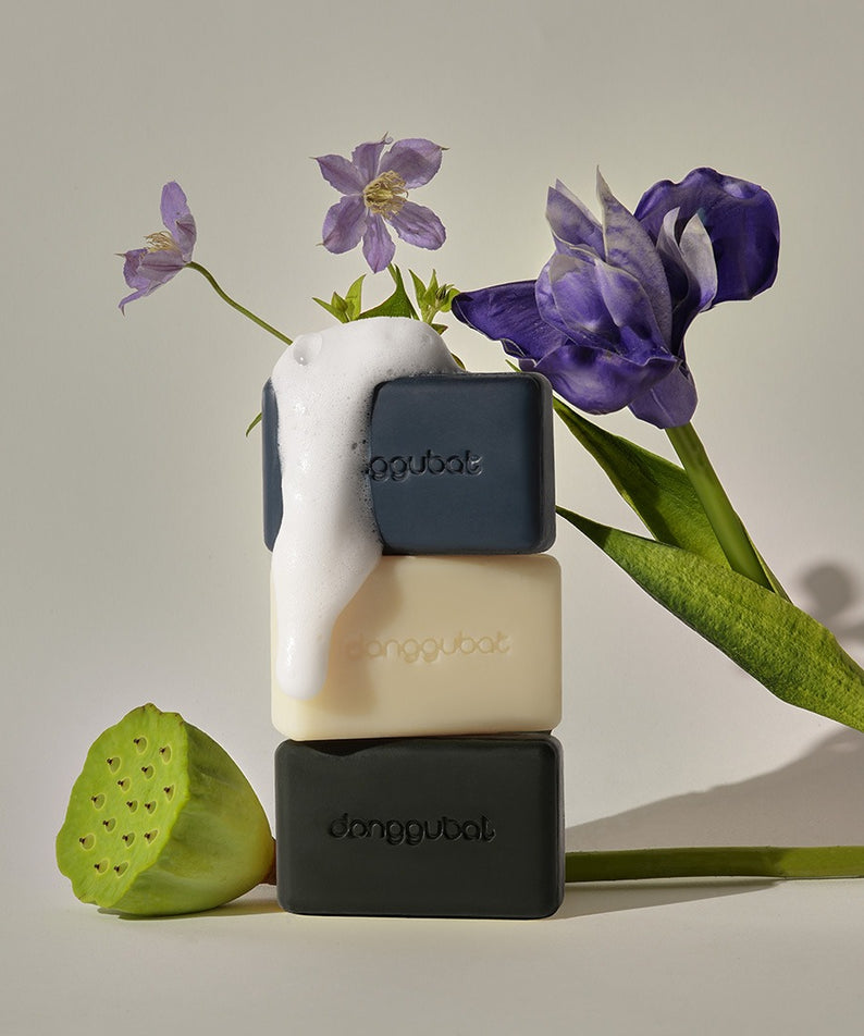 DONGGUBAT Field Blooming Perfume Shampoo Bar Repair 80g, savon coiffant au parfum floral, marque posée avec fleurs violettes.
