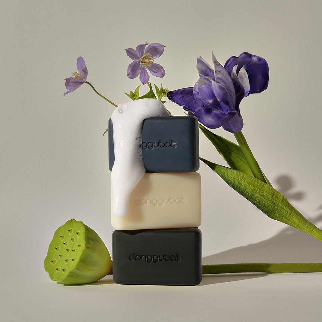 DONGGUBAT Field Blooming Perfume Shampoo Bar Repair 80g, savon coiffant au parfum floral, marque posée avec fleurs violettes.