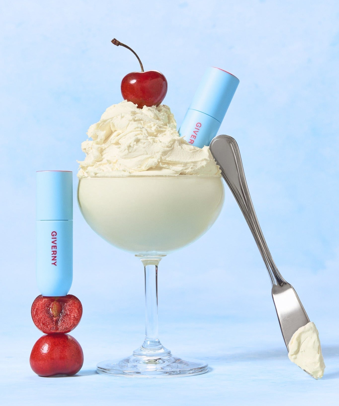 Rouge à lèvres GIVERNY Fluffy Sheer Tint 3.5g présenté de manière créative avec de la crème, une cerise et un fond bleu.