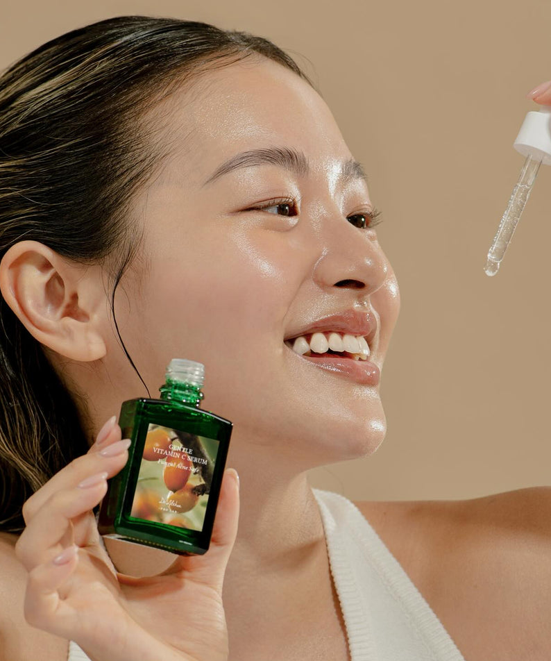 Femme appliquant le sérum DR.ALTHEA Gentle Vitamin Serum 30ml pour une peau éclatante. Soins visage en bouteille 30 ml.