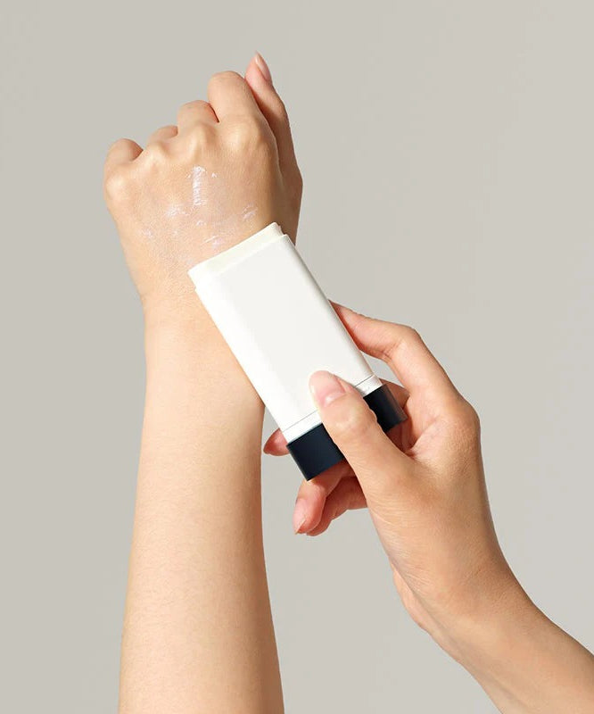 DR.CEURACLE Pro Balance Comfort Sun Stick 18g, marque en stick solaire appliqué sur main, fond clair, photographie produit.