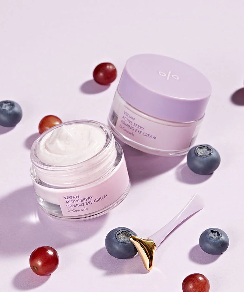 Pot de DR.CEURACLE Vegan Active Berry Firming Eye Cream entouré de baies, avec un outil applicateur.