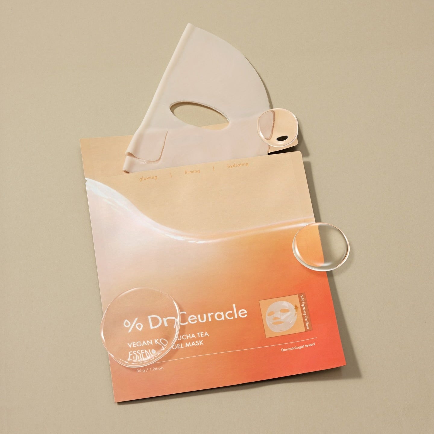 Décris l'image en français : DR.CEURACLE Vegan Kombucha Tea Essence-in-Gel Mask, marque sur masque en gel, posé sur fond beige.