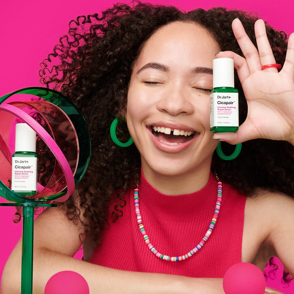 Photo produit : DR.JART+ CicapairI ntensive Soothing Repair Serum 30ml, sérum apaisant, flacon sur fond rose avec personne