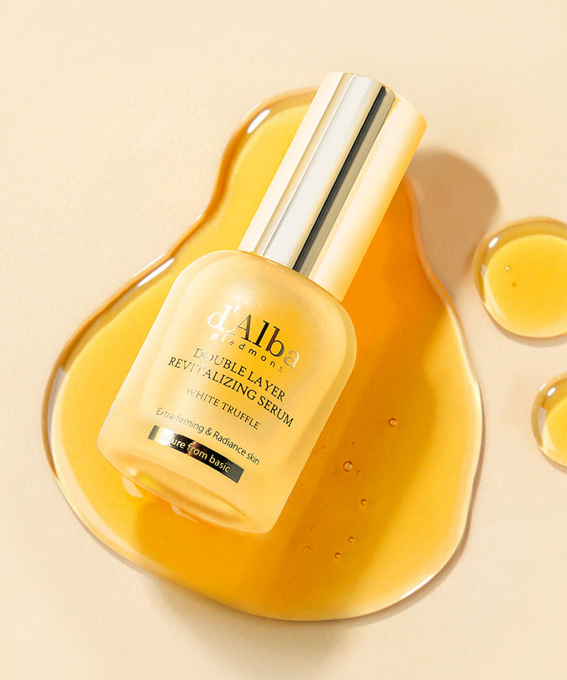 Sérum D'ALBA Vegan Double 30ml sur fond de couleur miel avec éclaboussures. Luxueux soin de la peau nourrissant et hydratant.