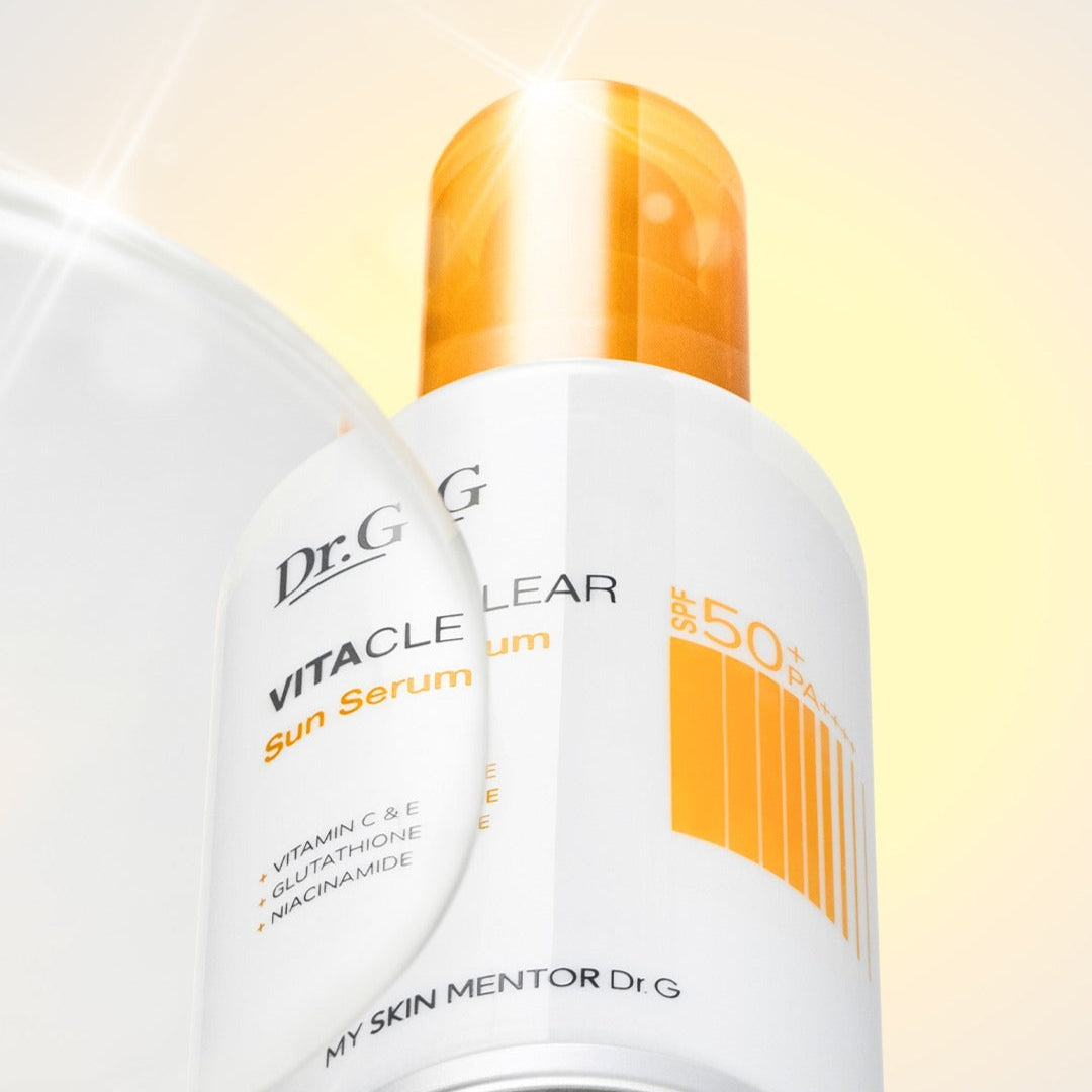 Décris l'image en français : Dr.G Vita Clear Sun Serum 50ml, flacon blanc et jaune Dr.G, contexte ensoleillé sur fond crème.