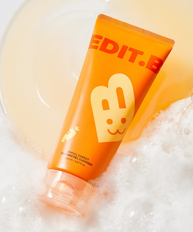 Tube de 150ml de EDIT.B Joyful Carrot Foaming Gel Cleanser sur un fond moussant.