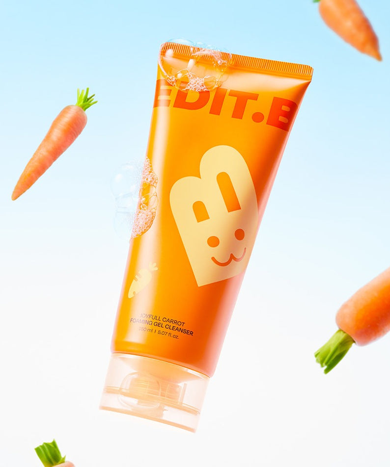 Flacon de gel nettoyant moussant EDIT.B Joyful Carrot 150ml, accompagné de carottes flottantes, sur fond bleu.