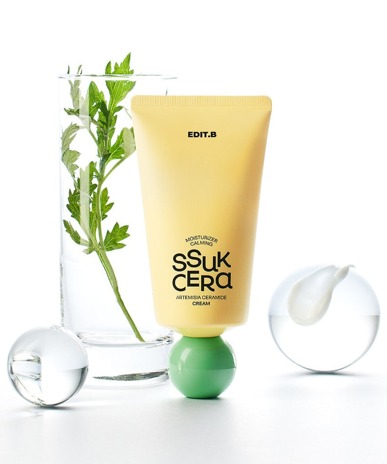 EDIT.B Moisturizing Soothing Mugwort Ceramide Cream 100ml en tube jaune devant un fond simple avec plante et sphères en verre.