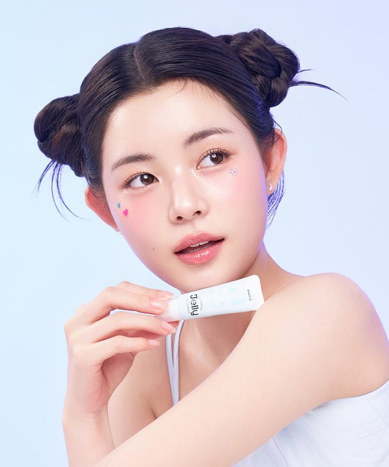 Jeune femme avec EDIT.B Waterful Jelly Lip Essence 11ml, montrée sur fond bleu, maquillage naturel, cheveux attachés.